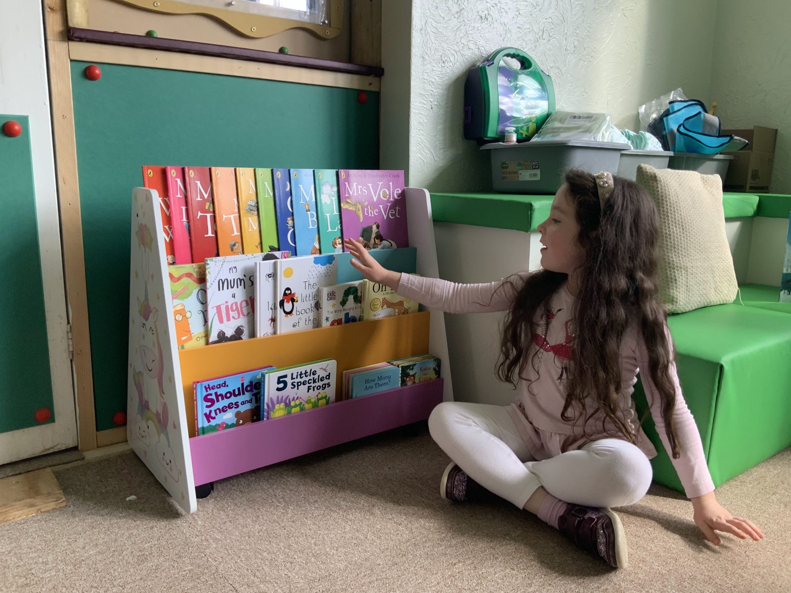 A child choosing a book in the quiet indoor reading corner